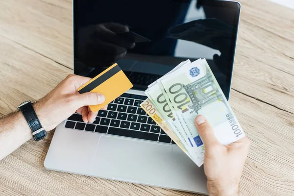 Tiro Recortado Pessoa Segurando Cartão Crédito Dinheiro Acima Laptop — Fotografia de Stock