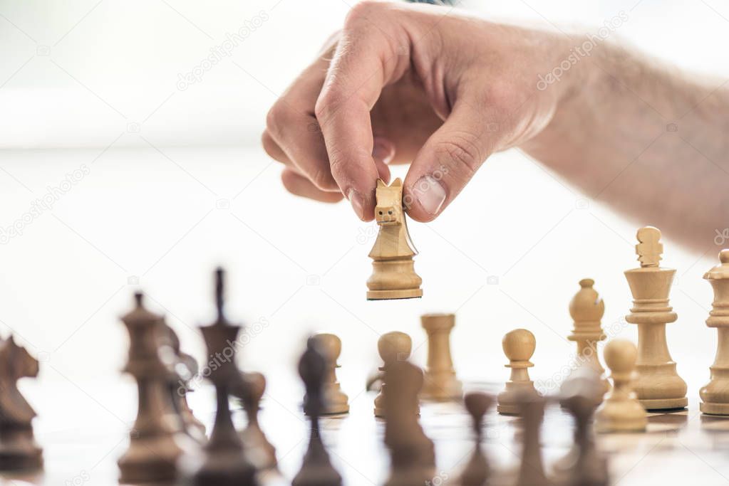 selective focus of person playing chess, cropped shot 