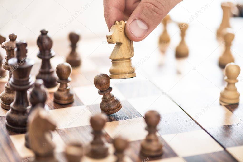 cropped shot of human hand playing chess, selective focus