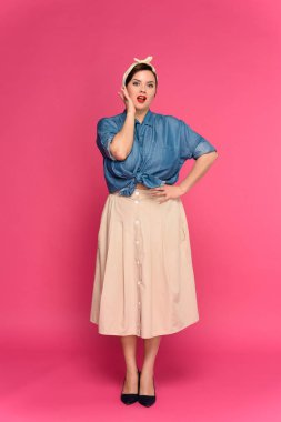 full length view of beautiful size plus pin up model looking at camera isolated on pink clipart