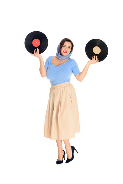 full length view of beautiful size plus pin up woman holding vinyl records and smiling at camera isolated on white 