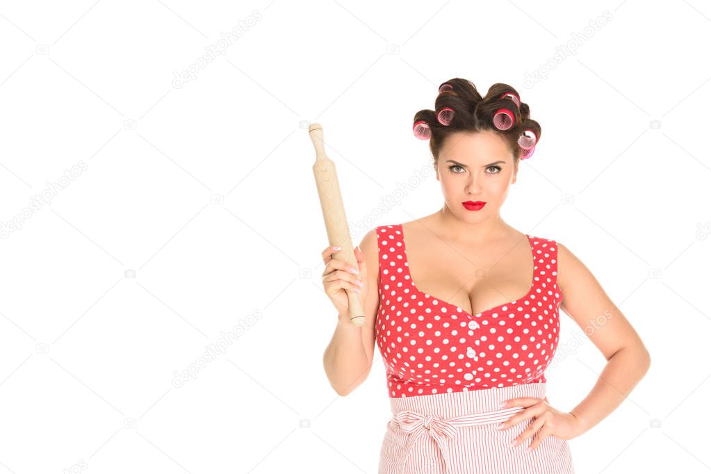 angry plus size housewife with wooden rolling pin looking at camera isolated on white