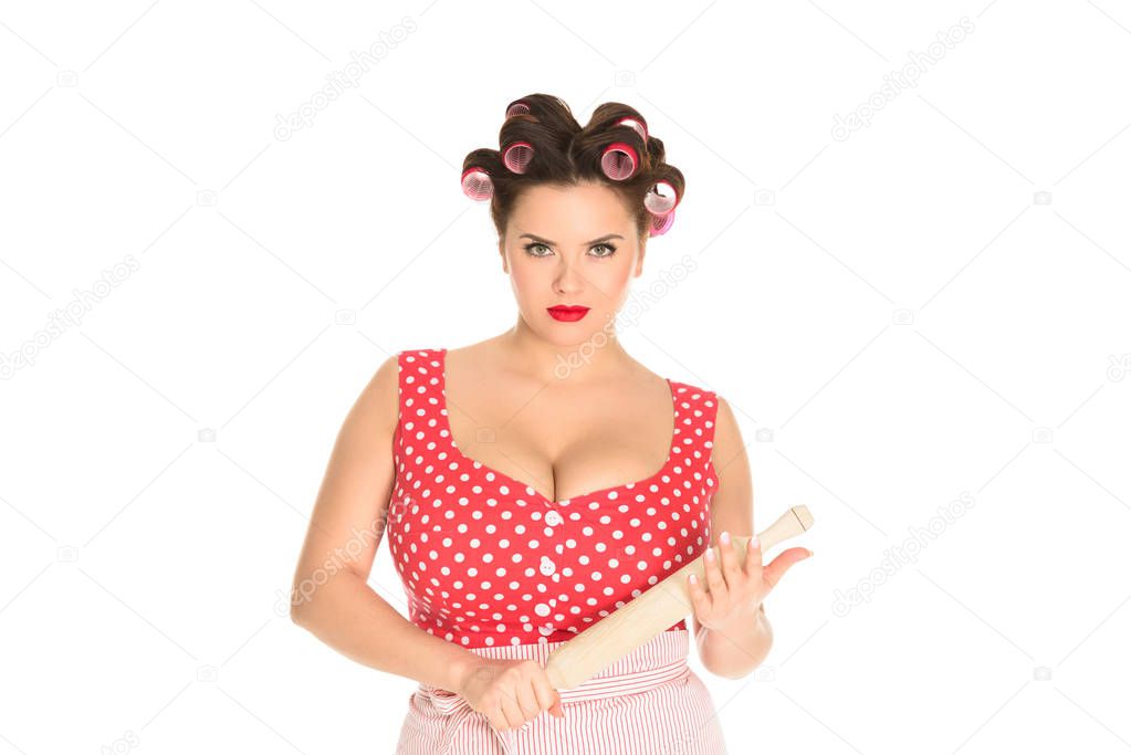serious plus size housewife with wooden rolling pin looking at camera isolated on white