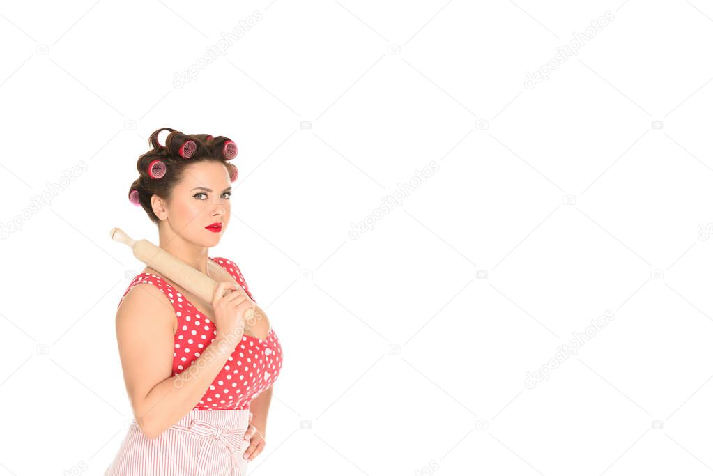 serious plus size woman with wooden rolling pin looking at camera isolated on white
