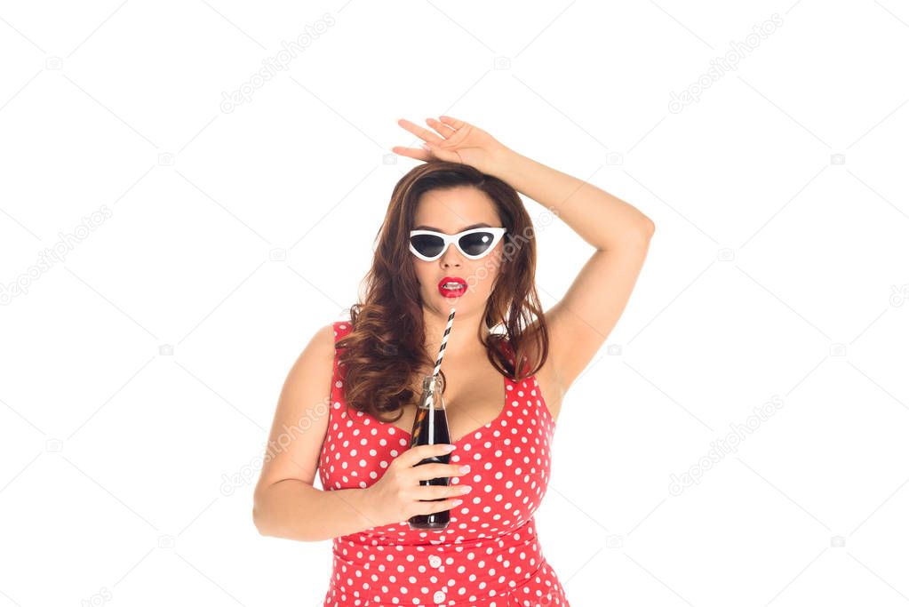 attractive plus size woman in dress and vintage sunglasses with bottle of soda isolated on white