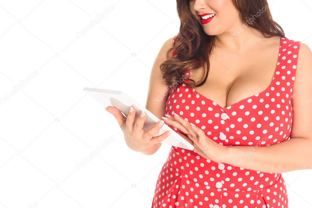 cropped shot of plus size woman in red dotted dress using tablet isolated on white
