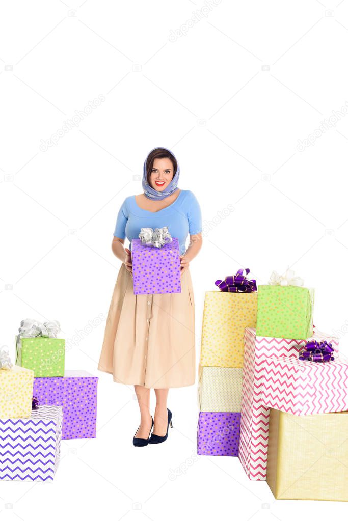 beautiful pin up woman holding present and smiling at camera isolated on white