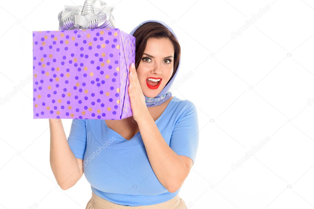 beautiful excited woman holding gift box and smiling at camera isolated on white