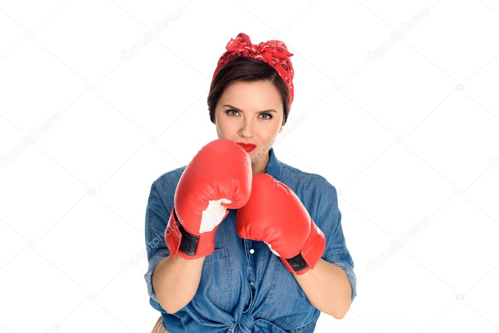 beautiful young pin up woman in boxing gloves looking at camera isolated on white