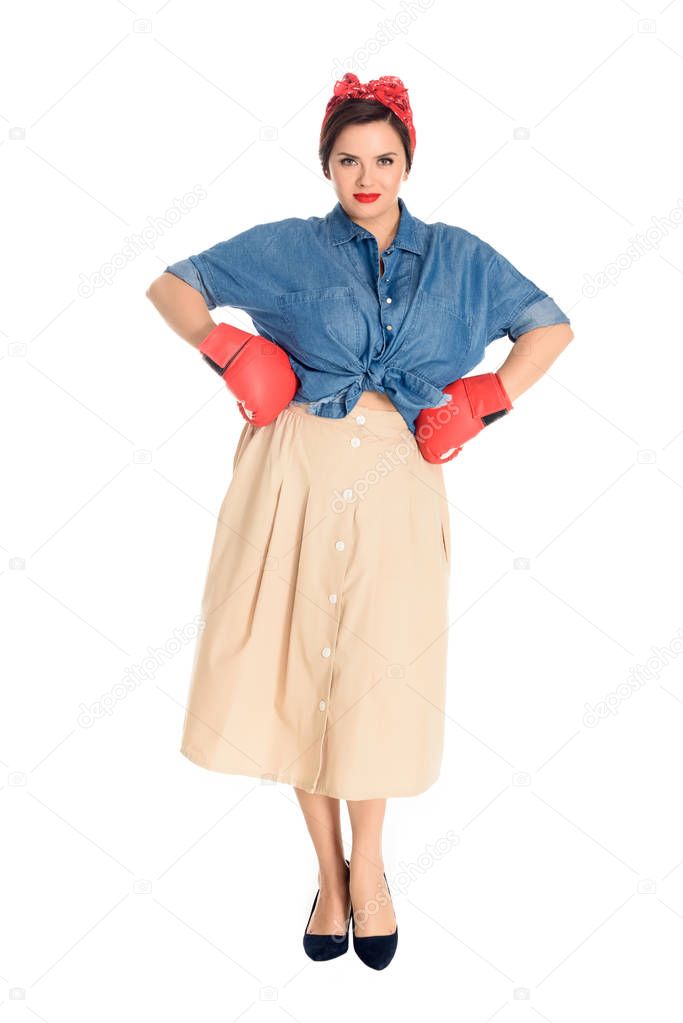 beautiful pin up woman in boxing gloves standing with hands on waist and looking at camera isolated on white