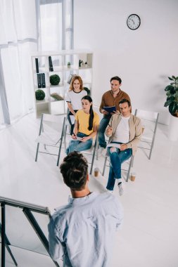 iş adamları iş Eğitim Office sırasında akıl hocası dinlerken kısmi görünümü