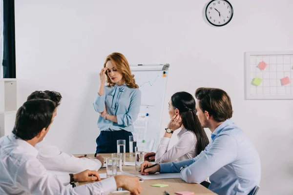 Selective focus of tired businesswoman and colleagues at workplace in office — Stock Image Selective Focus Tired Businesswoman Colleagues Workplace Office Stock Picture