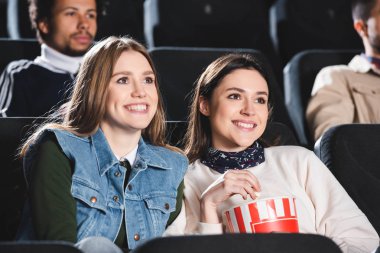 Sinemada film izleyen gülümseyen arkadaşların seçici odağı 