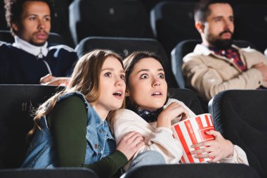 Patlamış mısırlı korkmuş arkadaşlarının sinemada film izlemelerinin seçici odağı 
