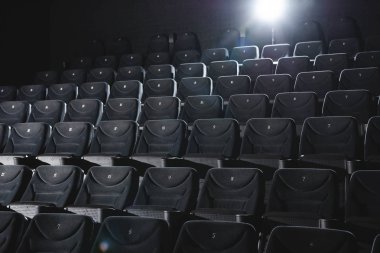 Karanlıkta gri koltuklu sinema salonu 