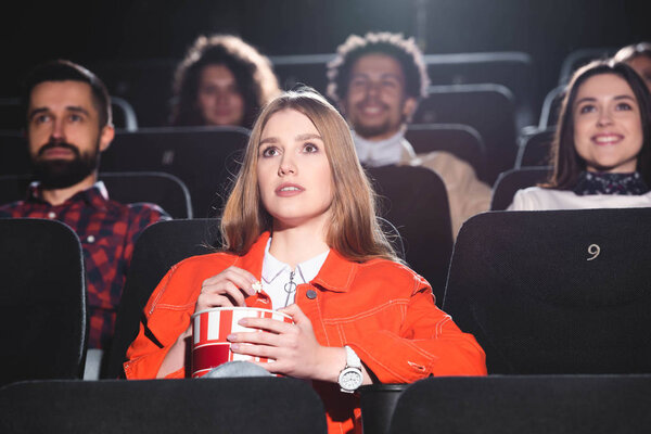 selective focus of attractive woman watching movie in cinema 