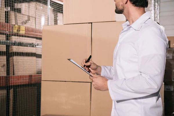 Cropped View Storekeeper White Coat Writing Clipboard Warehouse — Stock Photo, Image