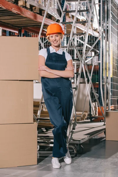 Lächelnde Arbeiterin Blickt Die Kamera Während Sie Mit Verschränkten Armen — Stockfoto