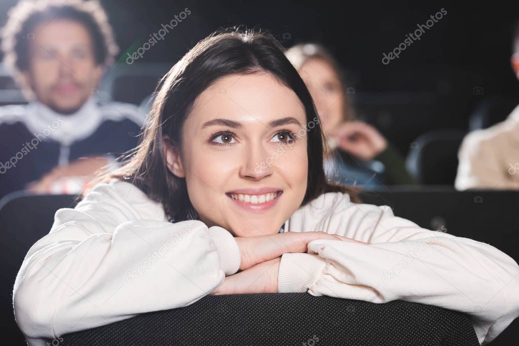 selective focus of smiling woman watching movie in cinema 