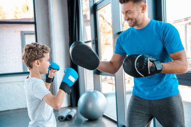Mutlu baba ve yakışıklı oğul spor salonunda boks yapıyor. 