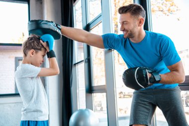 Mutlu baba ve yakışıklı oğul boks eldivenleriyle spor yapıyor. 