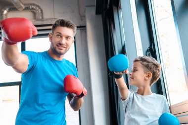 Oğlunun spor yaparken boks eldivenleriyle babasına baktığı seçici bir odak noktası. 