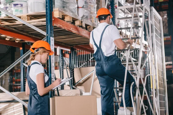 Workwoman Γράφοντας Στο Πρόχειρο Και Φορτωτής Στέκεται Στη Σκάλα Κοντά — Φωτογραφία Αρχείου