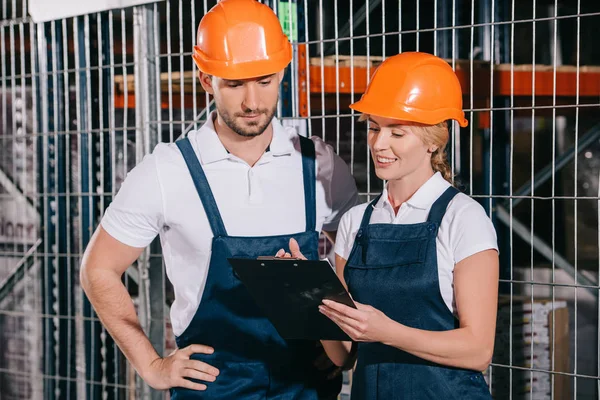 Smiling Workwoman Holding Clipboard While Standing Concentrated Workman — Stock Photo, Image