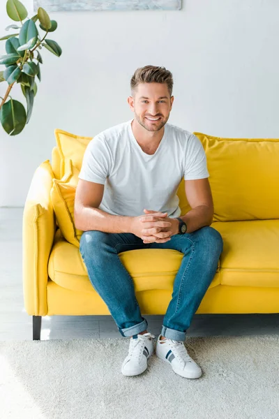 Hombre Feliz Sentado Con Las Manos Apretadas Sofá Casa — Foto de Stock