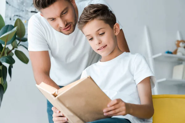 Enfoque Selectivo Padre Pie Cerca Lindo Hijo Sosteniendo Libro — Foto de Stock