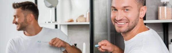 歯ブラシを持っている陽気な男のパノラマ写真 — ストック写真