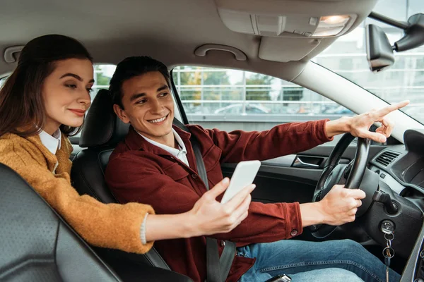 Mulher Passageiro Olhando Para Smartphone Enquanto Motorista Táxi Apontando Estrada — Fotografia de Stock