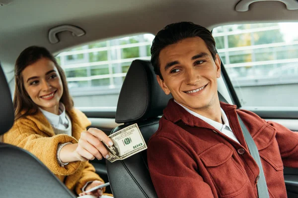 Uśmiechnięta Kobieta Pasażer Daje Gotówkę Taksówkarzowi — Zdjęcie stockowe