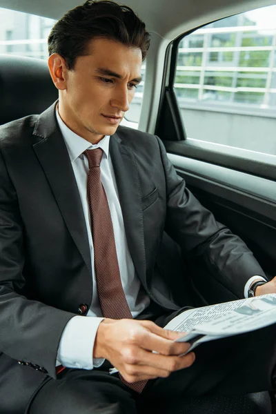 タクシーで新聞を読むハンサムなビジネスマン — ストック写真