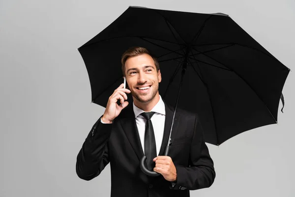 Bonito Sorridente Empresário Falando Smartphone Segurando Guarda Chuva Isolado Cinza — Fotografia de Stock