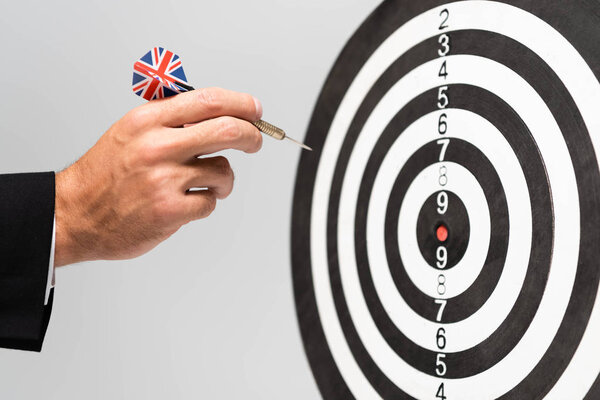 cropped view of businessman playing darts isolated on grey
