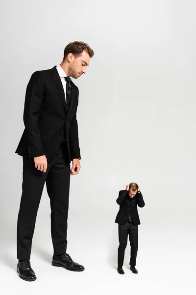 Hombre Negocios Traje Mirando Marioneta Asustada Sobre Fondo Gris — Foto de Stock