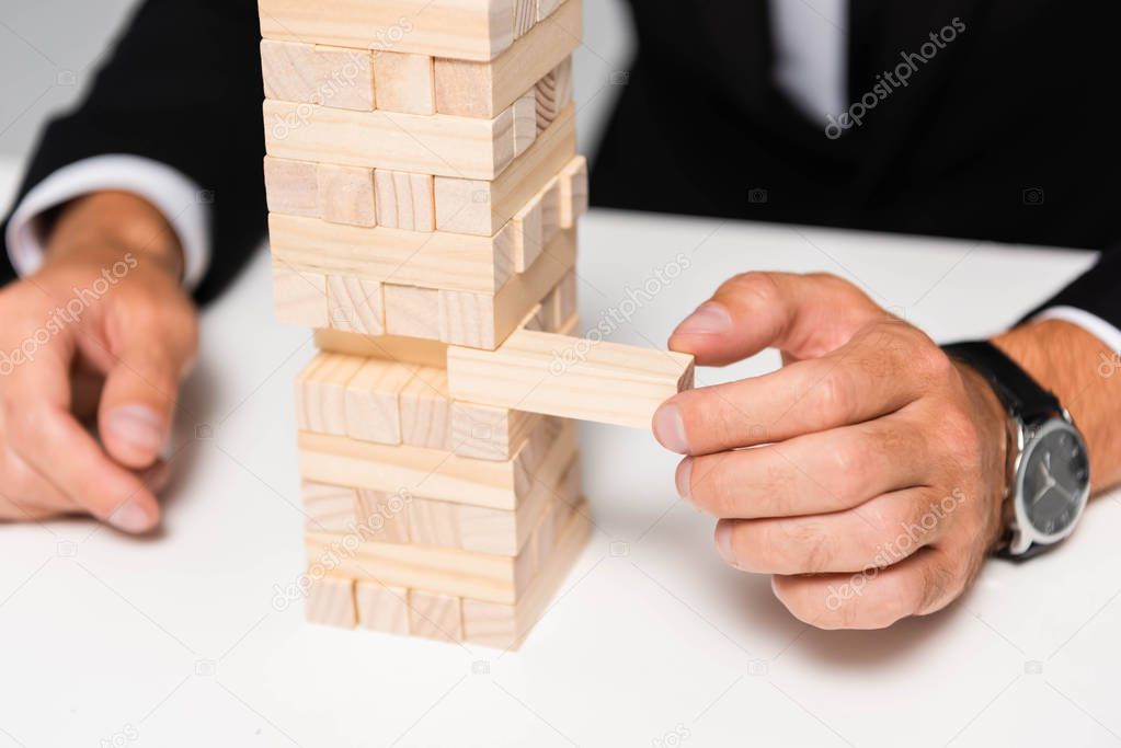 cropped view of businessman in suit playing blocks wood game 