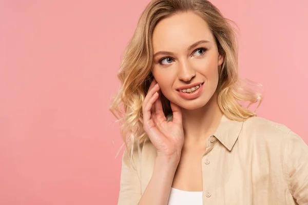 Leende Kvinna Med Tandställning Tittar Bort Isolerad Rosa — Stockfoto