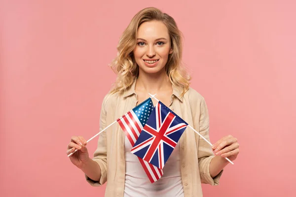 Mulher Loira Sorridente Segurando Bandeiras Americanas Britânicas Isoladas Rosa — Fotografia de Stock
