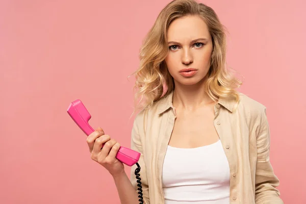 Mulher Loira Séria Segurando Telefone Auscultador Isolado Rosa — Fotografia de Stock