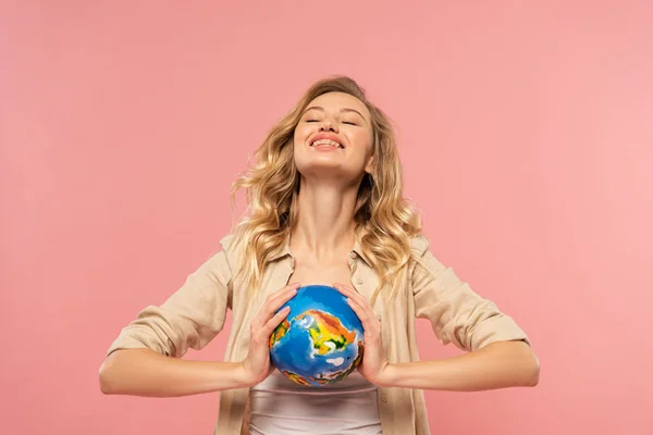 Glimlachende Blonde Vrouw Houden Globe Geïsoleerd Roze — Stockfoto