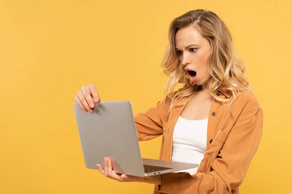 Mulher Loira Chocada Olhando Para Laptop Isolado Amarelo — Fotografia de Stock