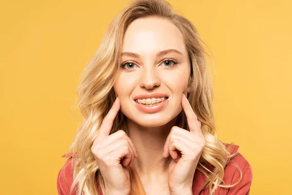 Smiling Blonde Woman Dental Braces Looking Camera Isolated Yellow — Stock Photo, Image