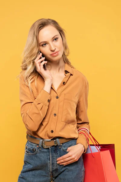 Mujer Rubia Hablando Smartphone Sosteniendo Bolsas Aisladas Amarillo — Foto de Stock