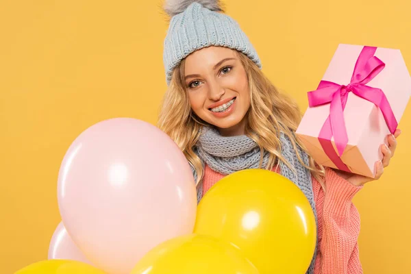 Mujer Sonriente Sombrero Bufanda Sosteniendo Globos Caja Regalo Aislada Amarillo — Foto de Stock