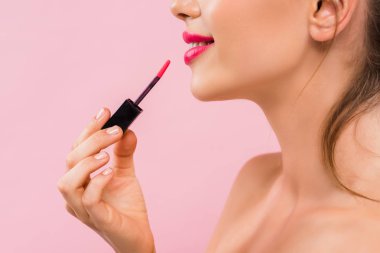 cropped view of smiling naked beautiful woman with pink lips applying lip gloss isolated on pink  clipart