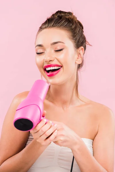 美丽而快乐的女人 嘴唇粉红 闭着眼睛 手里拿着用粉红隔开的吹风机 — 图库照片