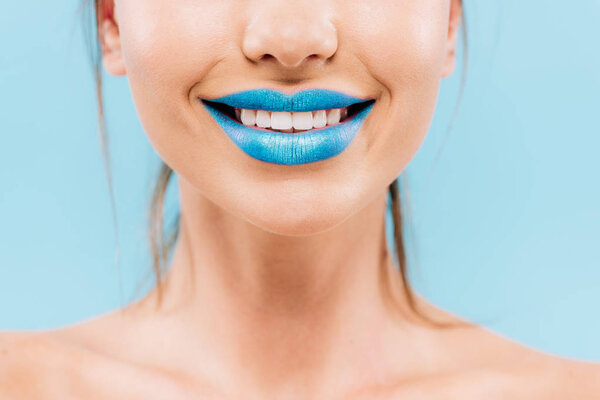 cropped view of smiling naked beautiful woman with blue lips isolated on blue