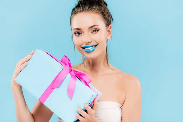 青い唇を持つ幸せな美しい女性は青い上に隔離された贈り物を保持 — ストック写真